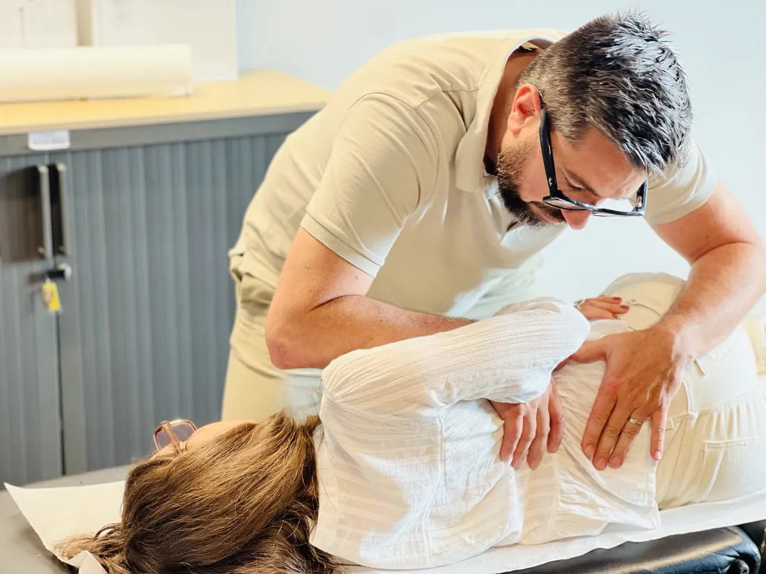 Ostéopathe en séance auprès d’une patiente allongée sur le côté